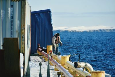 Rear view of man standing on pier