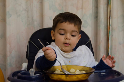 Boy eating food in bowl
