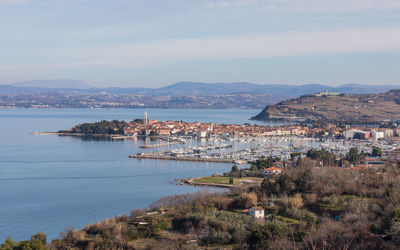 High angle view of townscape by sea against sky