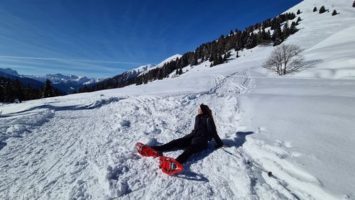 Person on snow covered field against mountain