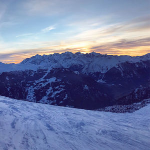 Scenic view of snowcapped mountains against sky during sunset