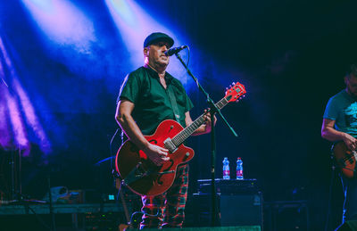 Young man playing guitar at music concert