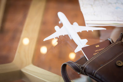 Close-up of model airplane with passport in bag on table