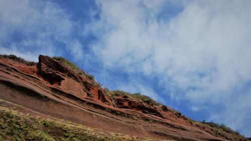 Low angle view of rocky mountain against sky