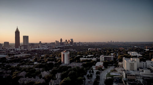 Aerial view of buildings in city at sunset