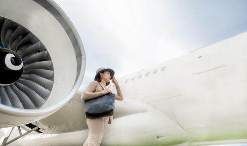 Full length of woman looking at camera against sky