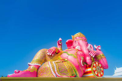 Low angle view of statue against blue sky