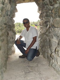 Portrait of young man sitting on rock