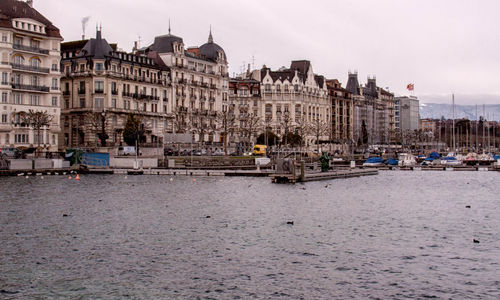 Buildings at waterfront against sky
