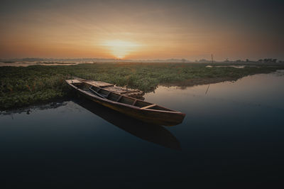 Boat in lake during sunset