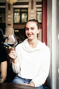 Portrait of smiling mid adult woman holding drink