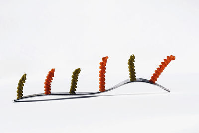 Close-up of colored pencils over white background