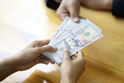 High angle view of hand holding paper with tattoo on table