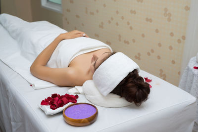 Midsection of woman resting on bed