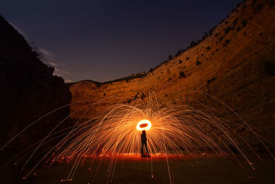 Blurred motion of illuminated lights against sky at night