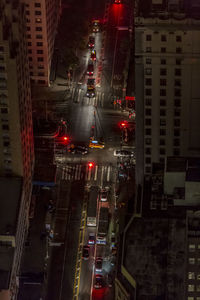 High angle view of traffic on road amidst buildings at night