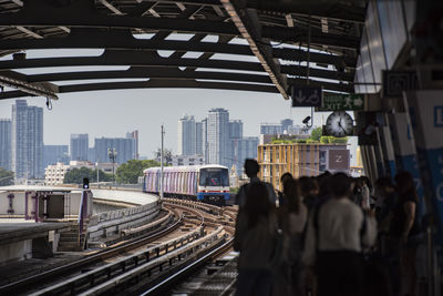 Rear view of people walking on railroad station