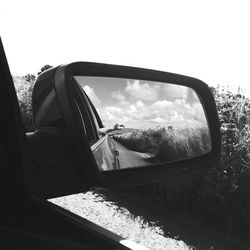 Reflection of sky on side-view mirror of car