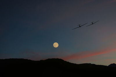 Low angle view of silhouette mountains against sky at night