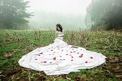 Young woman standing on field in forest