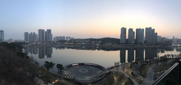 Reflection of buildings in city at sunset