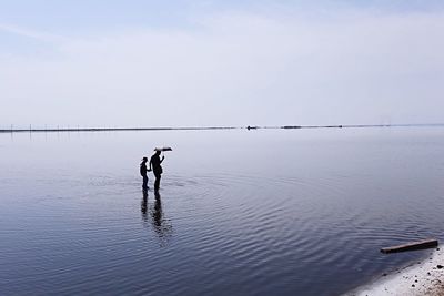 Men on beach against sky