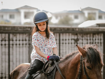 Aisan school kid riding or practicing horae at horse ranch