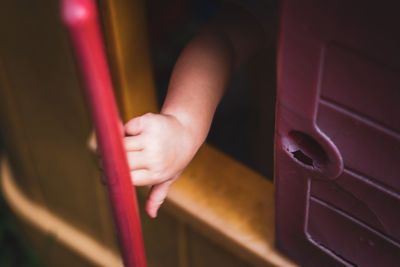 Cropped hand of toddler seen through window