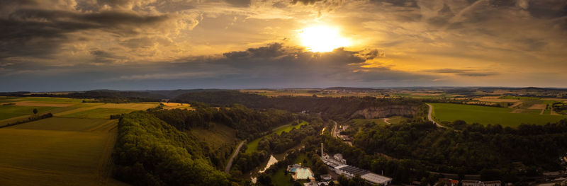 Panoramic shot of agricultural field against sky during sunset