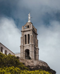 Low angle view of santa cruz church ,oran, against cloudy sky