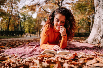 Young woman sitting on book