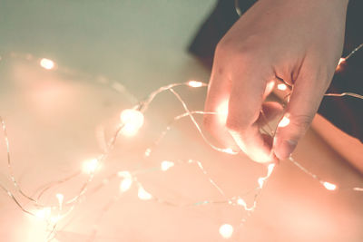 Close-up of hand on illuminated lighting equipment