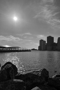 Sea by buildings against sky in city