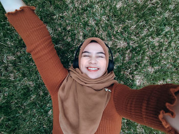 Portrait of young woman standing against plants