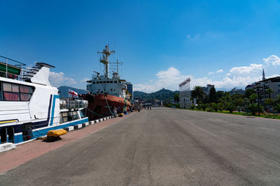 Road by harbor against sky in city