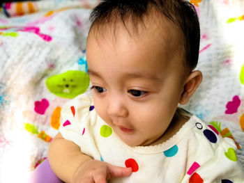 Close-up portrait of cute baby on bed