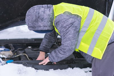 Side view of man repairing car