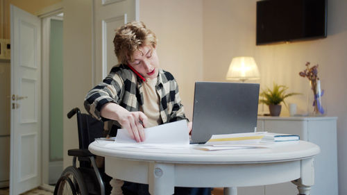 Woman sitting on table at home