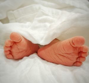 Close-up of baby feet on bed