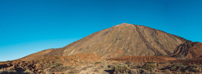 Scenic view of mountains against clear blue sky