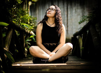 Young woman looking down while sitting outdoors