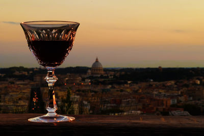 Close-up of wine glass against cityscape
