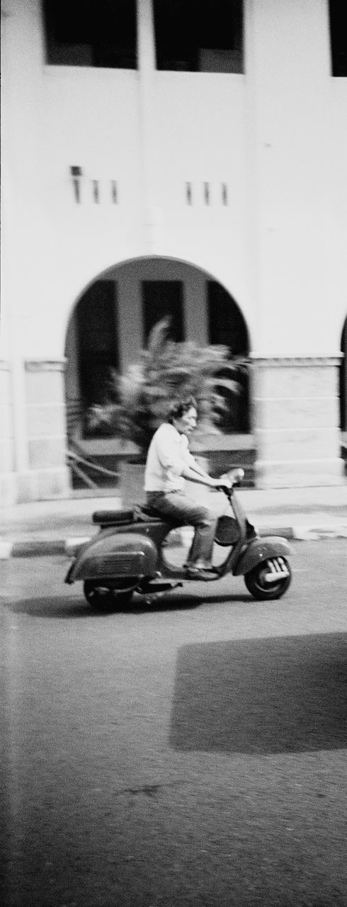 black, white, transportation, architecture, black and white, motion, mode of transportation, full length, monochrome, blurred motion, men, city, one person, monochrome photography, lifestyles, building exterior, built structure, street, day, land vehicle, child, sitting, leisure activity, riding, person, childhood, vehicle, adult, speed, outdoors, women, casual clothing, skateboard, on the move, road, sports