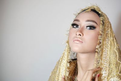 Portrait of beautiful bride against wall