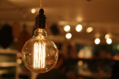 Close-up of illuminated light bulb with filament