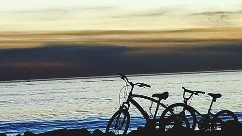 Close-up of bicycle by sea against sky
