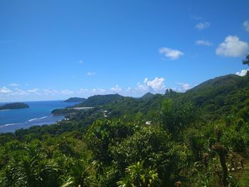 Scenic view of sea and mountains against blue sky