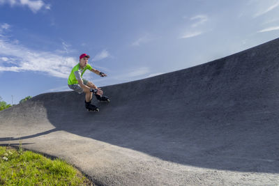 Male athlete skating on pump track during sunny day