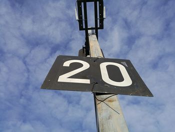 Low angle view of road sign against sky