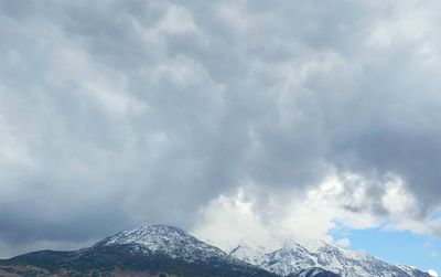 Low angle view of snowcapped mountain against sky